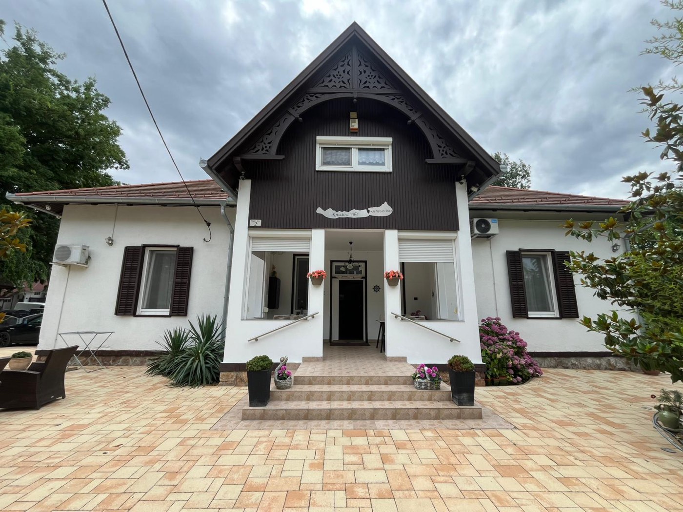 A Krisztina Villa homlokzata Balatonlellén, virágos bejárattal
